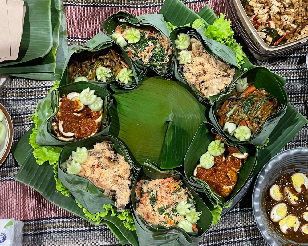 An array of food laid out decoratively in banana leaves, ready for the ceremony to begin