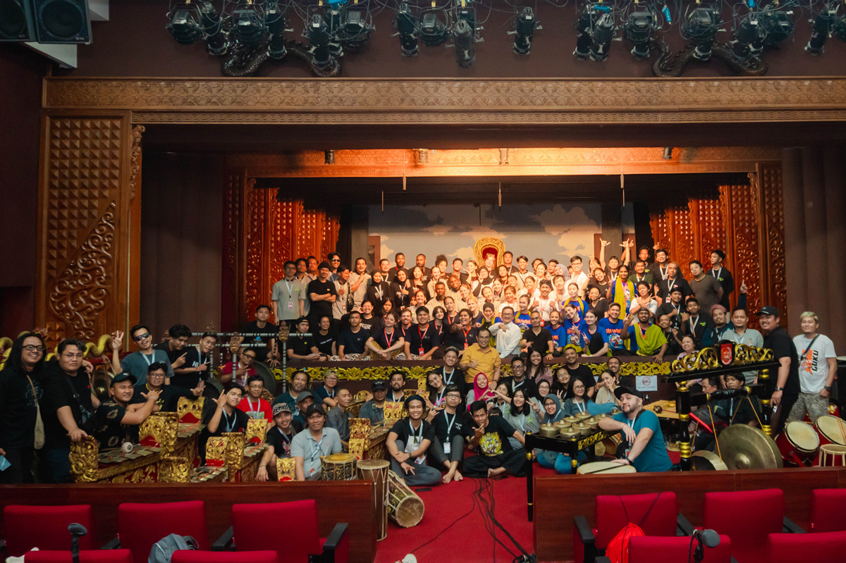 Group photo of the Indonesian Arts & Culture Program awardees and organisers sitting on and around the stage at Gedung Wayang Orang Bharata in Jakarta